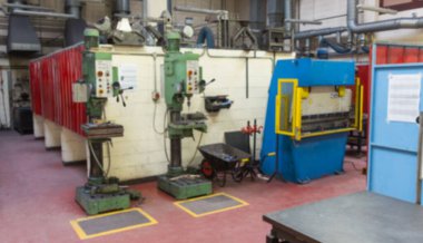 İki yeşil matkap, düz tasarım atölyesinde mavi bükme freniyle duruyor. Endüstriyel, imalat, makineler, endüstriyel tasarım, mühendislik, işçilik, hassasiyet