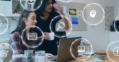 Kadın dizüstü bilgisayarda yazarken, erkek eğitim için analitik simgelere katılıp öğreniyor. İşbirliği, yenilik, çalışma alanı, dijital, etkileşim, beyin fırtınası, teknoloji