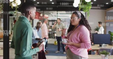 Erkek iş arkadaşı akıllı telefonu kaldırarak kadın çalışana aktarıyor ve verileri üst üste koyan ölçümleri tartışıyor. İşbirliği, gayri resmi, mola, ağ oluşturma, iletişim, başlangıç, modern