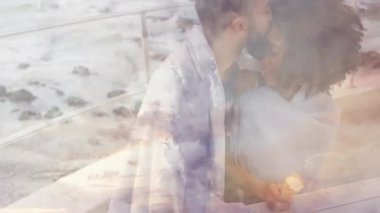 Tahta kaldırımda battaniye örten bir adam onlara okyanus manzarası için rehberlik ediyor. Romantizm, bağlantı, sükunet, doğa, şefkat, samimiyet, manzara