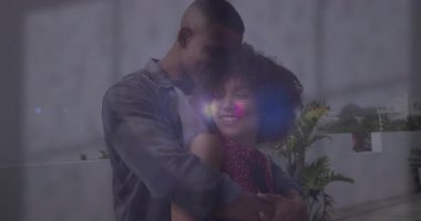 Bir adam balkonda kadının arkasına geçiyor, romantizm için kollarına sarılıyor, mercek yanıp sönüyor. Romantizm, şefkat, sükunet, açık hava, canlı, bağlantı, yakınlık