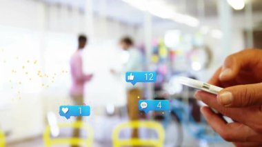 Akıllı telefon kullanıcıları ekranı dinliyorlar ve ofiste sarı parçacıklı bağlılık simgeleri oluşturuyorlar. İşbirliği, iletişim, teknoloji, sosyal ağ, takım çalışması, dijital etkileşim, ofis ortamı