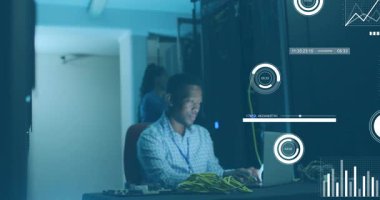 Bilgisayar ve iş arkadaşı şalteri indiriyor. Ağ trafiğini takip eden grafikleri gösteriyor. Teknoloji, veri, siber güvenlik, altyapı, işbirliği, dijital, izleme