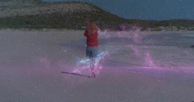 Mor enerji ayaklarda titreşiyor. Sahilde koşan kadın görsel efektler sergiliyor. Kozmik, neon, ruhani, canlı, fütüristik, enerjik, macera