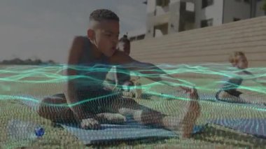 Çocuklar mavi minderlerde nefes alıyor, menteşe yapıyor ve nefes veriyor. Fitness seansı sırasında dalga kaplamasını başlatıyorlar. Yoga, arkadaşlık, açık hava, esneme, egzersiz, takım çalışması, sağlık