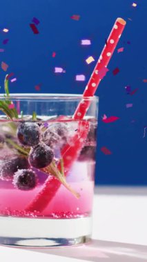 Konfeti düşüşünün animasyonu ve mavi arka planda kokteyl. Parti, içki, eğlence ve kutlama konsepti dijital olarak oluşturulmuş video.