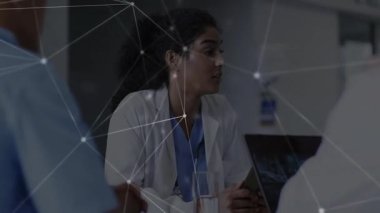 Kadın doktor tableti tıkırdatırken aynı zamanda kılavuz tıp ekibi toplantısını da gösteriyor. Tıbbi, işbirliği, modern, profesyonel, sağlık, teknoloji, iletişim