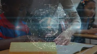 Öğretmen ders kitabı metnini işaret ediyor ve öğrencilere yol gösterirken holografik dünyayı başlatıyor. Eğitim, akıl hocalığı, dijital, yenilik, sınıf, öğrenme, işbirliği