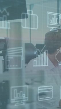 Ofisteki bilgisayarı kullanan çeşitli iş adamları üzerinde simge ve veri işleme animasyonları. Küresel iş, finans, bilgisayar ve veri işleme kavramı dijital olarak oluşturulmuş video.