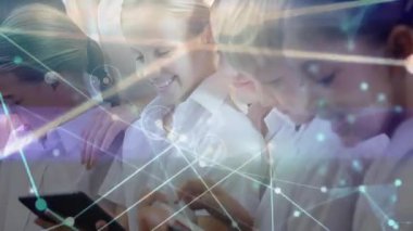 Öğrenciler tabletleri ve telefonları dinliyorlar ve işbirlikçi öğrenme etrafında ağ hatlarının titremesine neden oluyorlar. Eğitim, teknoloji, takım çalışması, yenilik, arayüz, iletişim, gençlik