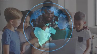 Öğretmen dizüstü bilgisayarın üzerine eğiliyor mavi dünyayı başlatıyor öğrencilerin üzerinde dönüyor ve öğrencilere neşe saçıyor. Eğitim, akıl hocalığı, dijital öğrenme, çok kültürlü, takım çalışması, yenilik, keşif