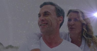 Bir kadın kıyı şeridinde erkeğin arkasında el ele tutuşarak alyansları ortaya çıkarıyor. Romantizm, bağlantı, dinginlik, aşk, mutluluk, birliktelik, doğal