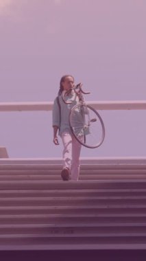 Spots of light against african american man carrying his bicycle walking down the stairs. pedal day awareness concept