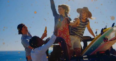 Arkadaşlar sörf reklamını kutluyor, bira şişelerini altın konfetileri eşliğinde bagaj kapağında gezdiriyorlar. Kutlama, dostluk, açık hava, eğlence, sahil, yaşam tarzı, mutluluk