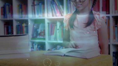 Çocuk kız, sayfalarda holografik halkalar ve veri çizgilerinin belirmesine neden olarak öğrenmek için kitap açıyor. Eğitim, merak, yenilik, dijital, okur yazarlık, gençlik, öğrenme