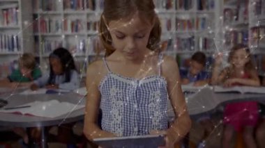 Kütüphanede akranlarıyla tableti tıkırdatan ve araklayan bir kız kameraya gülümseyen rafları gösteriyor. Eğitim, öğrenme, teknoloji, sınıf, öğrenim, odak, keşif