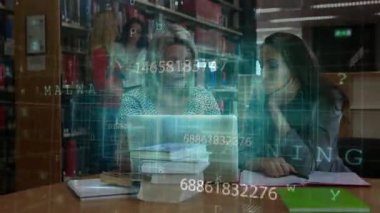 Üçüncü öğrenci, öğrenciler dizüstü bilgisayar verilerini incelerken kütüphanede volta atıyor. İşbirliği, araştırma, veri görselleştirme, eğitim, dijital, akademik, teknoloji