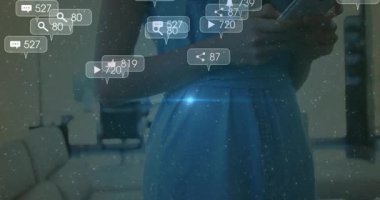 Yüzen sosyal medya simgeleri ve yükselen gülümseyen yüzüyle evde telefonu kaydıran kadın. Teknoloji, bağlantı, dijital, iletişim, modern, sosyal, canlı