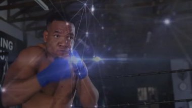 Şebeke yumrukları eşleştirip antrenman yaparken boksör ringde pozisyon değiştiriyor. Atletik, dijital, fütürist, dövüş, güç, konsantrasyon, teknoloji