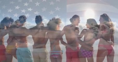 Dostlar kumlu sahilde yürüyor bayrak örtüsünü aktifleştiriyor gün batımında yolculuk anlarını paylaşıyorlar. Yoldaşlık, birlik, kutlama, açık hava, coşku, eğlence, arkadaşlık.