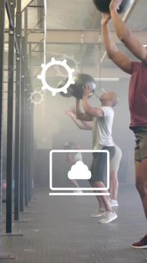 Spor salonunda toplarla egzersiz yapan farklı insanlar üzerinde iş ikonlarının canlandırılması. Spor ve dijital arayüz konsepti dijital olarak oluşturulmuş video.