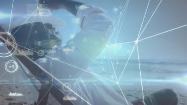 Kumsalda yüzen veri tablolarını okumak ve etkinleştirmek için yetişkin adam yetiştirme dergisi. Gelecekçi, teknoloji, rahatlama, deniz kenarı, dijital, yenilik, yaşam tarzı