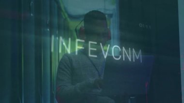 Veri merkezi teknisyeninin dizüstü bilgisayarda yazı yazması kırmızı devrelerin titreşmesine ve sızıntıya neden oluyor. Teknoloji, siber güvenlik, dijital, endüstriyel, yenilik, veri, ağ