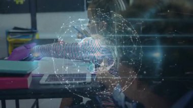 Kaleme uzanan ve onu tutan kız, sınıfta dönen şeffaf küresel örtüyü tetikliyor. Öğrenme, yaratıcılık, eğitim, yenilik, çocukluk, keşif, teknoloji