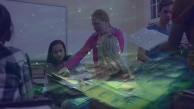 Ayakta duran öğrenci yeşil akıntılı notlara işaret ediyor, sınıf arkadaşları çalışmak için dizüstü bilgisayar kullanıyor. İşbirliği, eğitim, takım çalışması, dijital, gençlik, yenilik, öğrenim