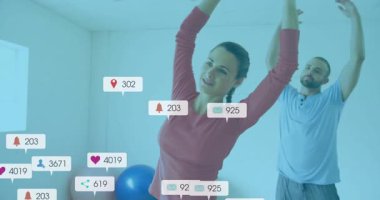 Fitness ikilisi ev jimnastik salonunda yan esneme ve aynalama başlatarak yüzen nişan ikonları oluşturuyor. Egzersiz, sağlık, canlılık, hareket, motivasyon, minimalizm, dijital