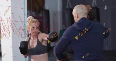 Antrenör, boks antrenmanı için eldiven değiştiriyor ve stajyere yardımcı oluyor. Eğitim, zindelik, güç, kararlılık, esneklik, hareket, spor kıyafetleri.