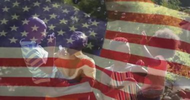 Bayrak solması aile rehberinin asaları batırdığını ve eğitici oyun için baloncuk çıkardığını gösteriyor. Aile, neşe, kutlama, eğlence, açık hava, tazelik, masumiyet.