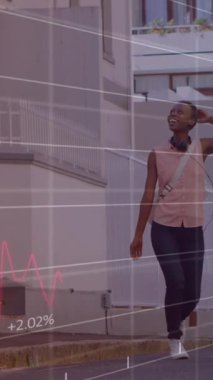 Sokakta yürüyen Afrikalı Amerikalı bir kadın üzerinde rakamlarla finansal veri işleme animasyonu. Küresel finansman, yaşam tarzı ve dijital arayüz kavramı dijital olarak oluşturulmuş video.