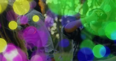 Arkadaşlar sosyal medya için ormanda toplanıyor, adam şişe içiyor ve Bokeh örtüsünün altında kadeh kaldırıyor. Açık hava, yoldaşlık, eğlence, coşku, rahatlama, doğa, yaşam tarzı.