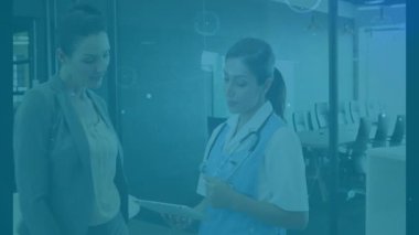 Holografik grafikler takım çalışmasına rehberlik ederken tıbbi ekip de klinikte veri incelemesi için tableti tıkırdatıyor. İşbirliği, sağlık, teknoloji, liderlik, yenilik, profesyonel, takım çalışması