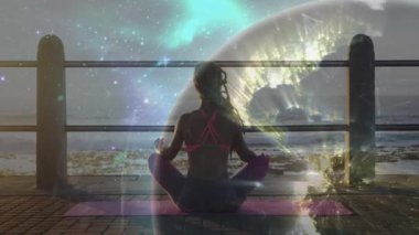 Yoga minderinde sağlıklı meditasyon yapan kadın, güneş doğarken ilham veren kozmik küre figürü. Spiritüellik, dinginlik, üstünlük, farkındalık, kozmik, barışçıl, içgözlem