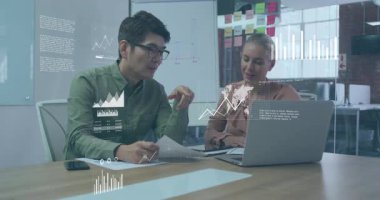 Veri analisti çizelge seçiyor ve iş analisti iş grafiklerini gözden geçirmek için dizüstü bilgisayarı açıyor. Analizler, işbirliği, yenilik, teknoloji, veri görselleştirme, kurumsal, profesyonel