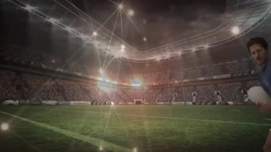 Mavi formayla başlayan spor örtüsü ragbi topuyla koşuyor ve defans oyuncusu yükseliyor. Atletizm, rekabet, eylem, hareket, teknoloji, aydınlanma, enerji