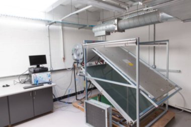 Büyük tekerlekli test aparatı düz dizayn laboratuvarında, açılı panel ve ağ kablolarıyla duruyor. Mühendislik, laboratuvar, endüstri, teknoloji, teşhis, yenilik, makine