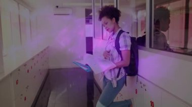 Eğitim öğrencisi dolaplara yaslanıyor ders kitabını açıyor ve komik bir şekilde gülümsüyor. Bilgi, eğitim, kütüphane, öğrenme, akademik, sınıf, konsantrasyon