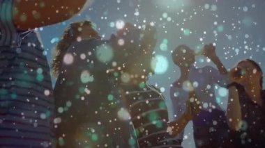 Arkadaşlar konfetiyle eğlenmek için güneşli sahilde şişe kaldırıp marakas sallıyorlar. Kutlama, eğlence, arkadaşlık, coşku, kıyı, şenlik, tasasız