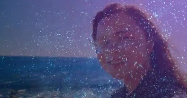 Parıltı, kadının başını okyanusa çevirip güzellik teması sergilemesini tetikliyor. Dinginlik, zarafet, doğa, sükunet, yansıtıcı, parıldayan, açık hava