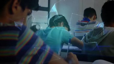 Sınıfta kalem yazan gri kapüşonlu öğrenci çokgen ağını aktifleştiriyor, dünyayı oluşturuyor. Eğitim, teknoloji, yenilik, işbirliği, öğrenme, dijital, gençlik