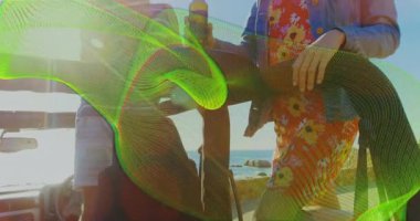 Cipte duran adam, kadının öne çıkıp şişelere uzanmasını ve sahildeki arkadaşlarına kadeh kaldırmasını tetikliyor. Kıyı şeridi, macera, boş zaman, açık hava, arkadaşlık, rahatlama, manzara