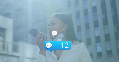 Yüksek binaların ortasında akıllı telefona konuşan bir kadın, sosyal medya yorumlarının kabardığını gösteriyor. Kentsel, teknoloji, iletişim, kutlama, ağ, modern, profesyonel