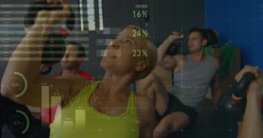 Grafikleri güncelleyerek spor salonunda kaybolan ölçümler üzerinde kettlebell omuz presi yapan sınıf. Fitness, strength, analytics, performance, training, wellness, digital