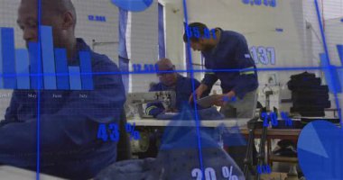 Denetmen, atölye rehberliğindeki kot pantolona işaret ediyor. Çizelgeler arasında kalite ayarlama makinesi. Sanayi, zanaat, takım çalışması, imalat, tekstil, kalite, yenilik