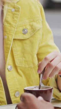 Kafkas kadının üzerinde yüzen, gülümseyen ve kahve içen kalp simgelerinin canlandırılması. Sosyal medya ve iletişim arayüzü kavramı dijital olarak oluşturulmuş video.