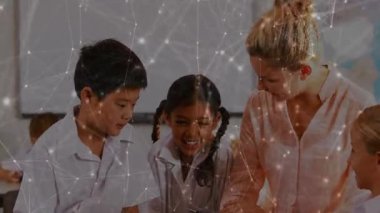 Bayan öğretmen iki öğrenciyi dijital derste tıklatarak rehberlik ediyor. Eğitim, işbirliği, teknoloji, öğrenme, sınıf, gençlik, yenilik