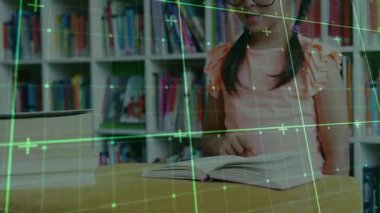 Öğrenci kız, yeşil şebekenin altına açık bir kitap koyuyor ve eğitici metinleri okuyor. Öğrenme, okuma yazma, keşif, merak, eğitim, görselleştirme, yenilik